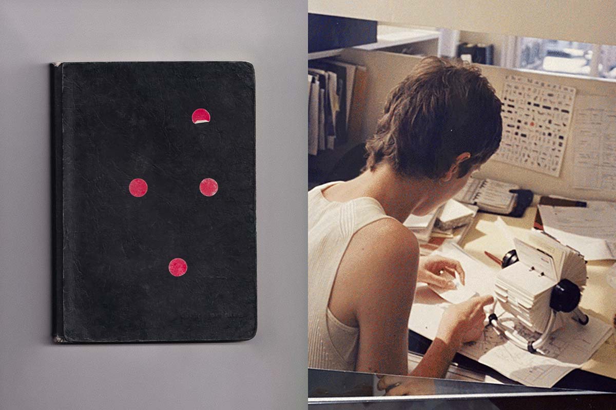 A photo of a black note book, with red circular stickers on it.